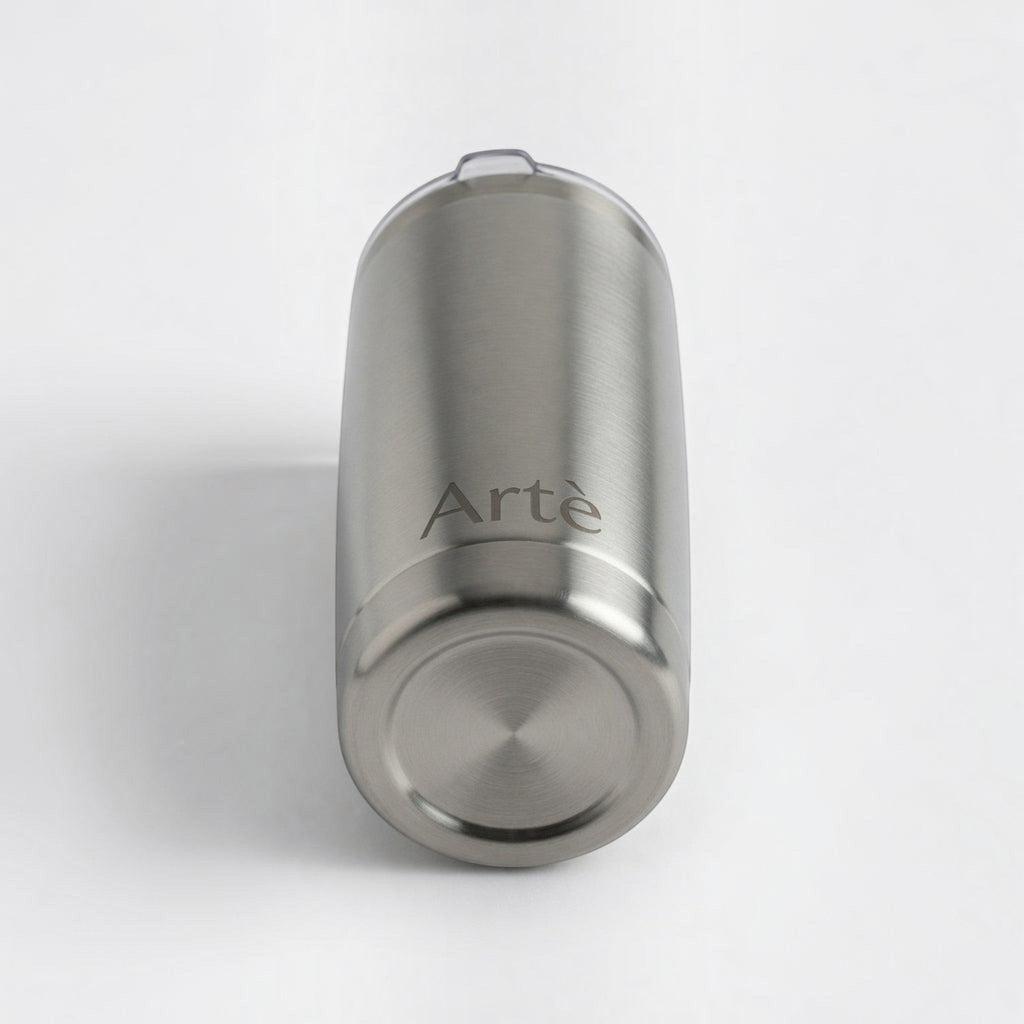 ArtèCup 20oz stainless steel tumbler with a brushed metal finish and clear lid, viewed from the bottom angle.